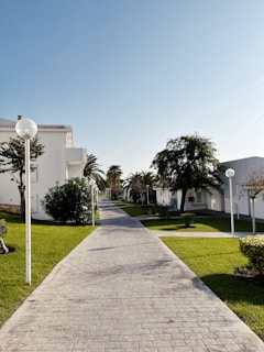a brick walkway leading to a white building