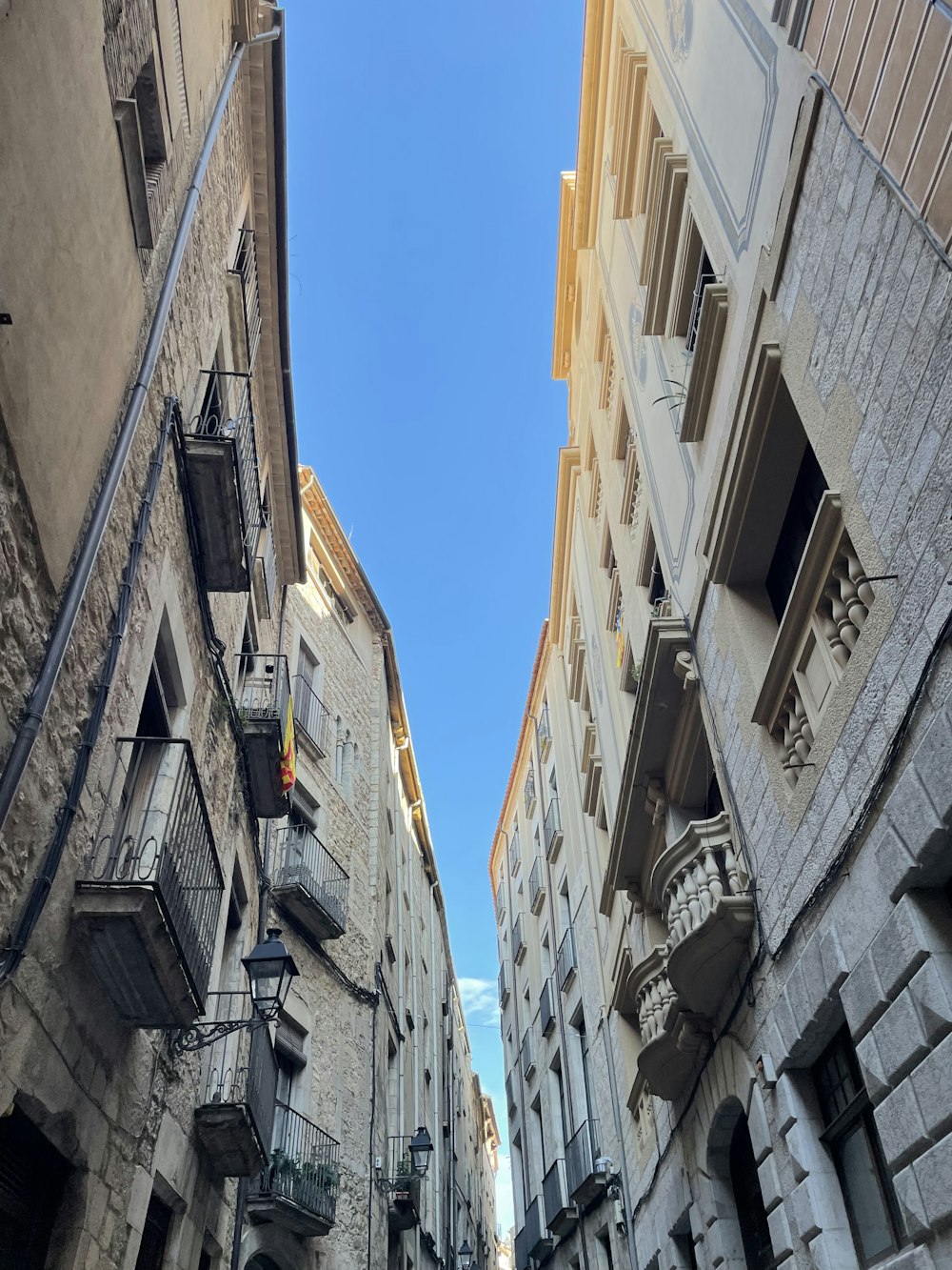 a narrow city street with stone buildings and balconies