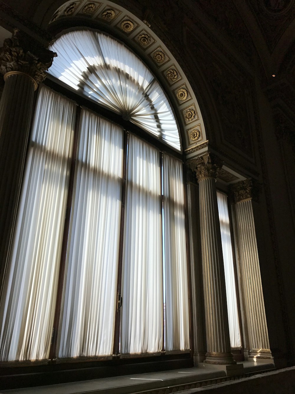 a large window with curtains and a clock