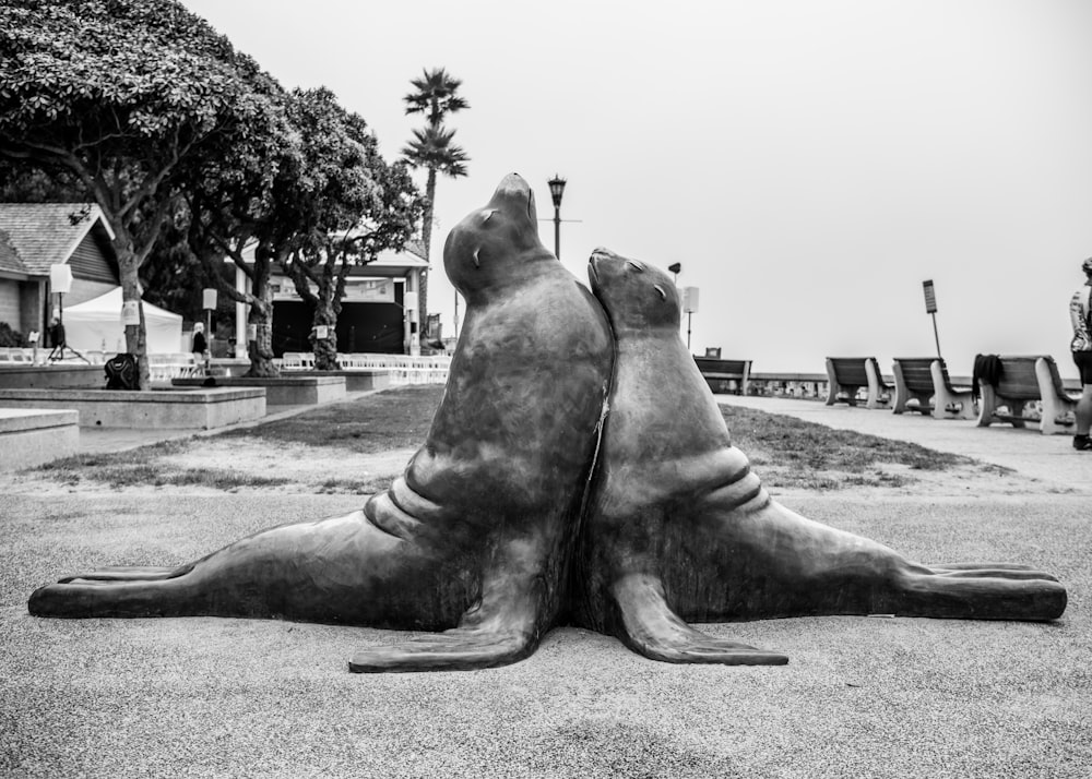 a couple of statues sitting on top of a cement ground