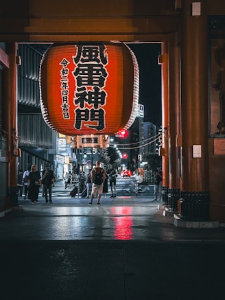 a group of people walking down a street next to tall buildings