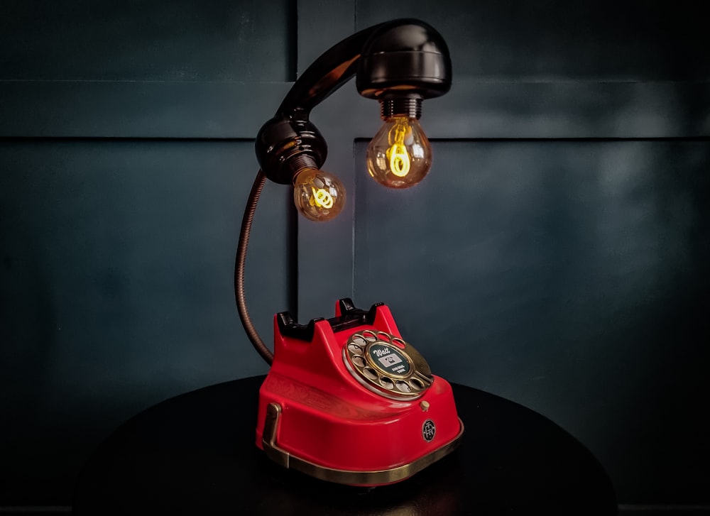ein rotes Telefon, das auf einem Tisch sitzt