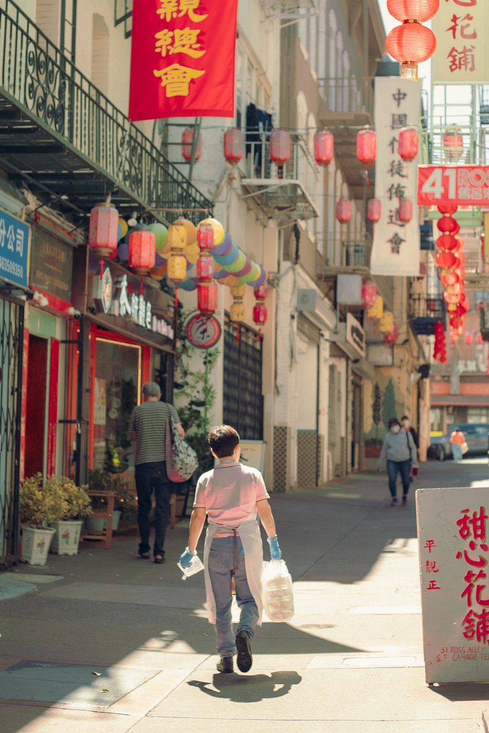 a woman walking down a street holding a bag