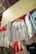 Several graphic sweatshirts are hanging on display outdoors. The clothes have various designs and logos, with some referencing San Francisco. They are arranged in a row under a bright yellow awning.