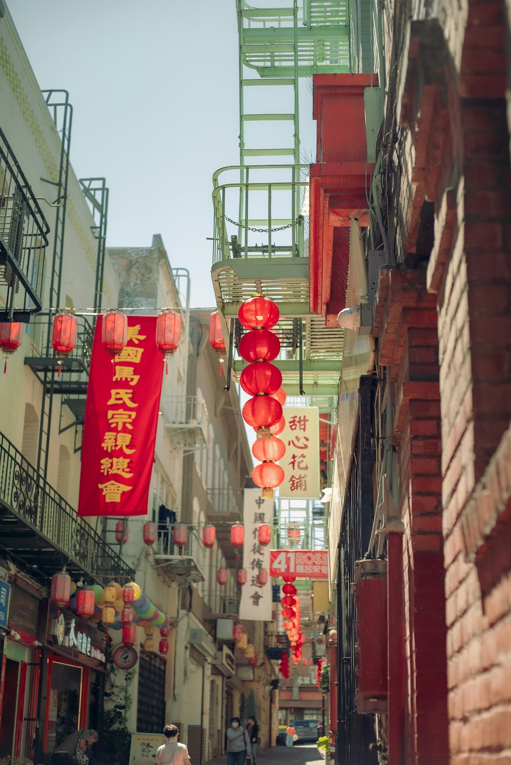 a narrow street with red lanterns hanging from the buildings