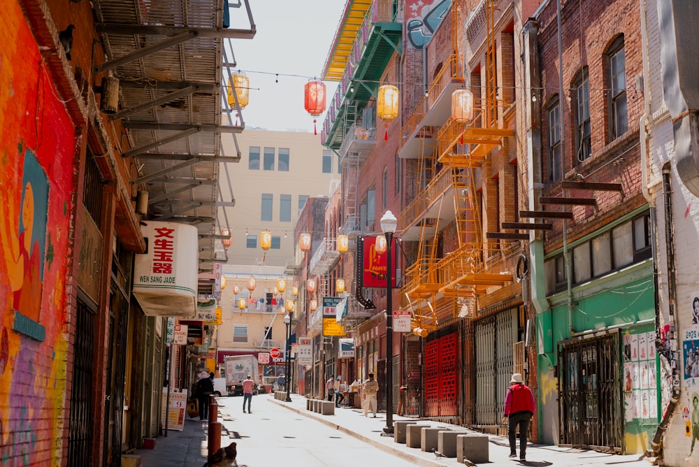 a man walking down a street next to tall buildings