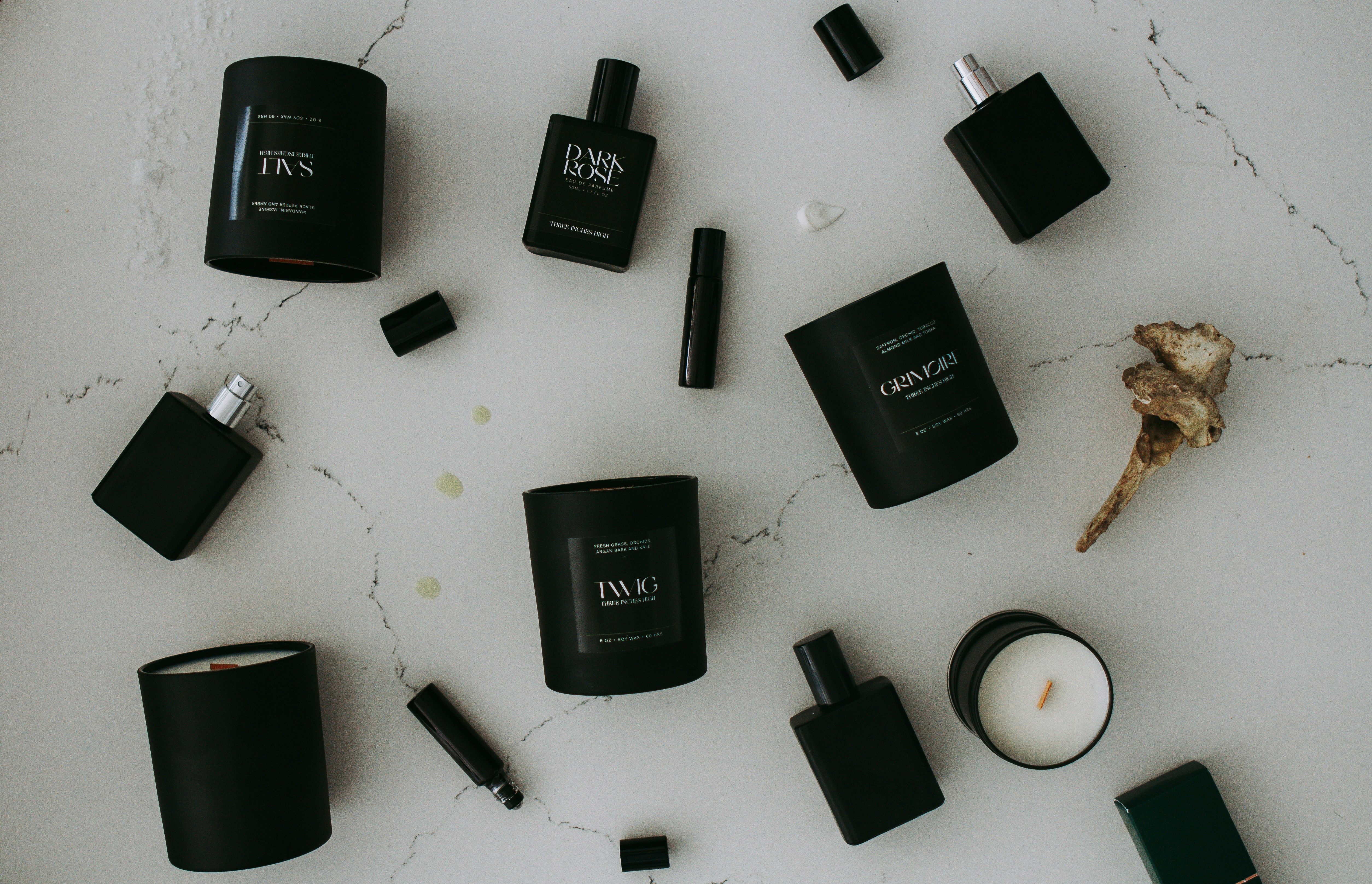 a table topped with black bottles and candles