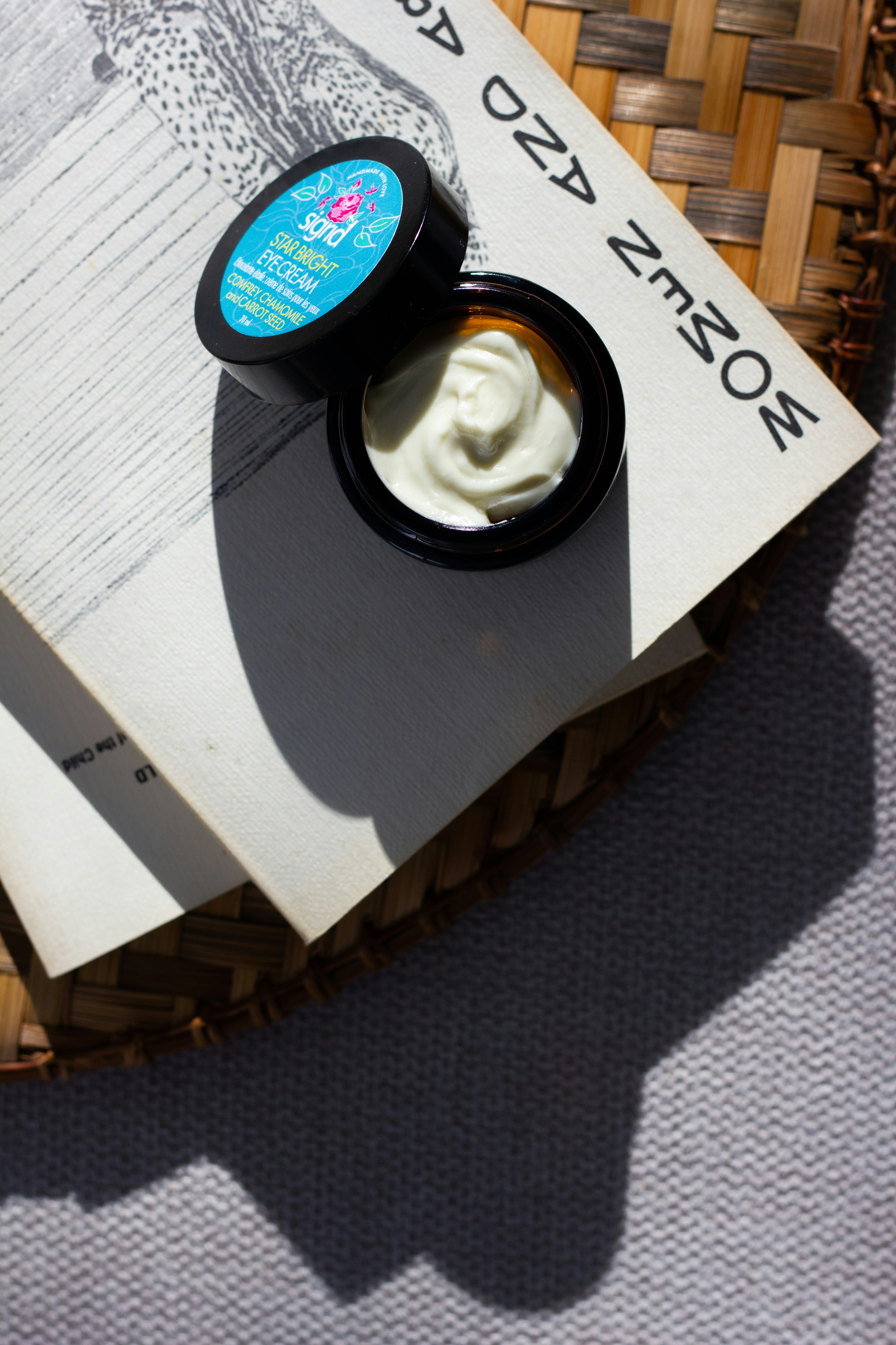 a jar of cream sitting on top of a book