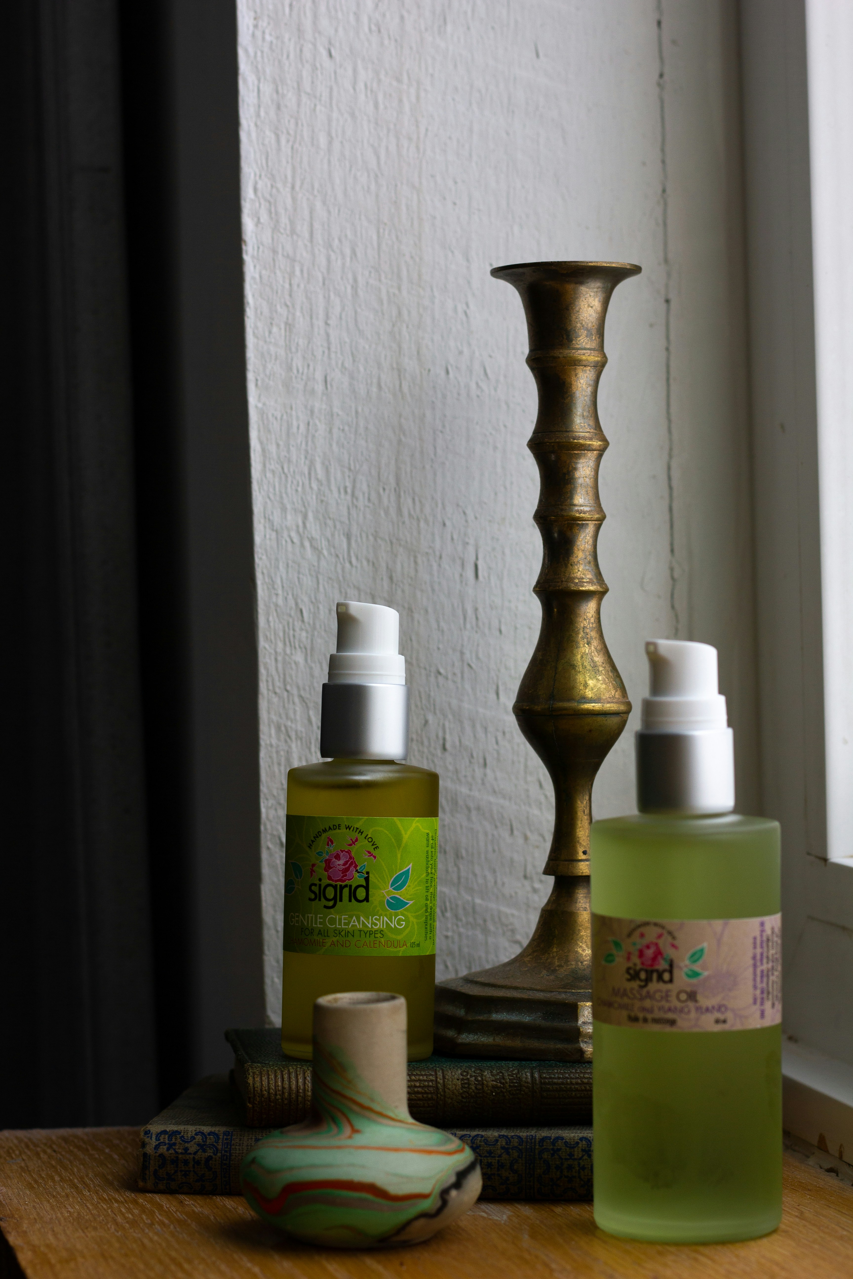 a wooden table topped with bottles of lotion and a candle