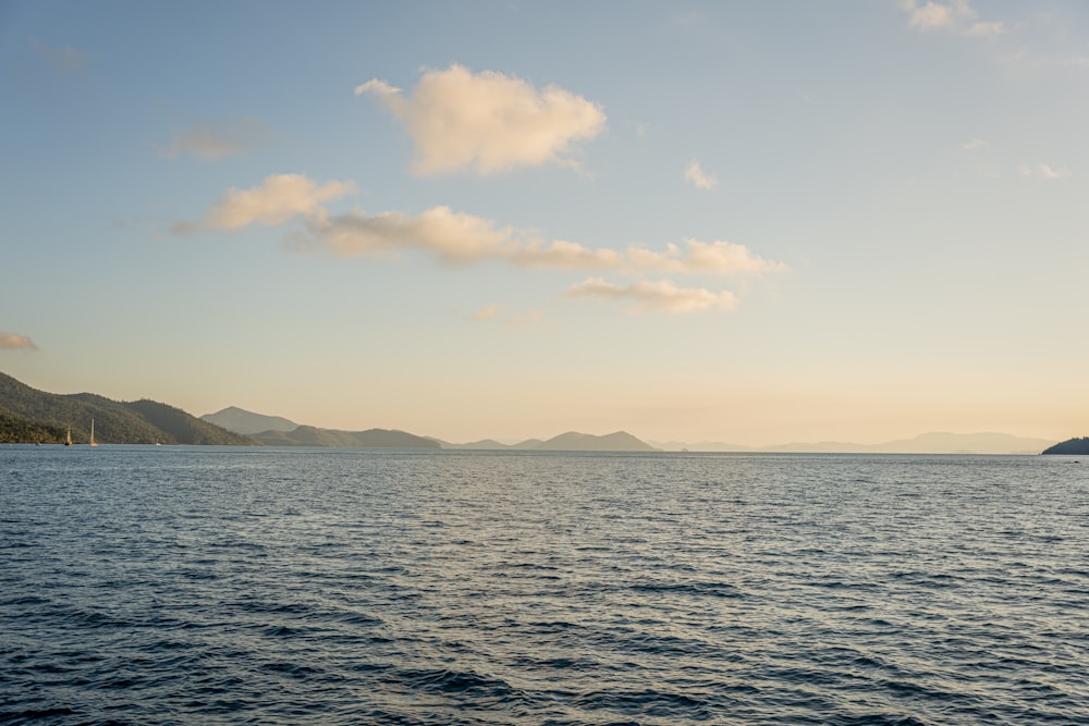 a body of water with mountains in the background