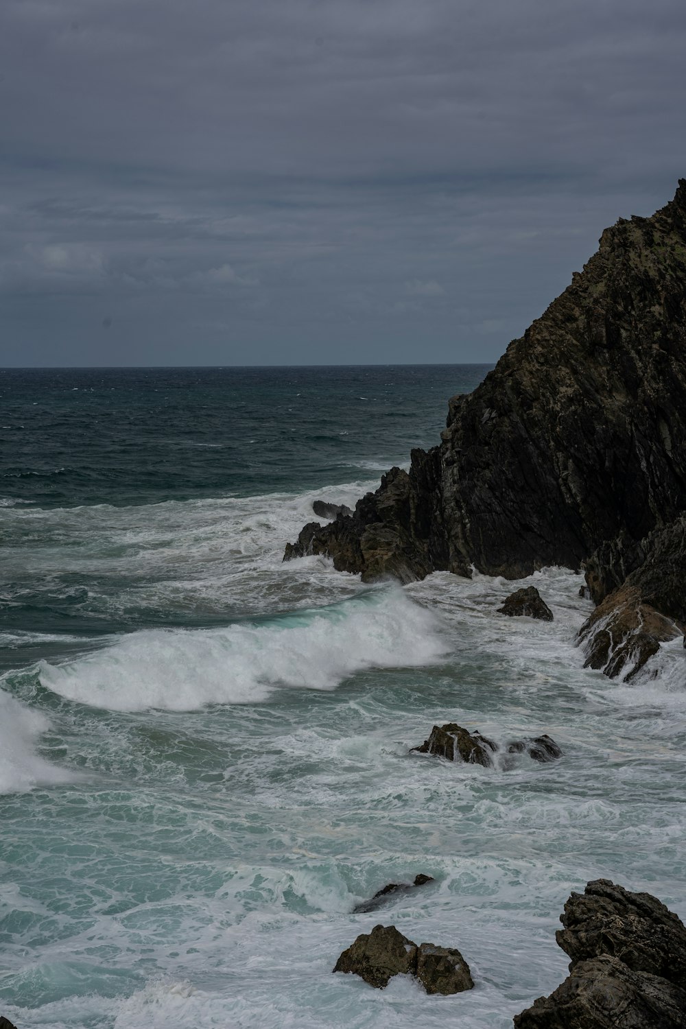 a large body of water next to a rocky shore