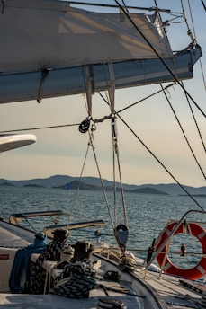 A smiling sailor adjusting sails on a sunny Greek island boat deck
