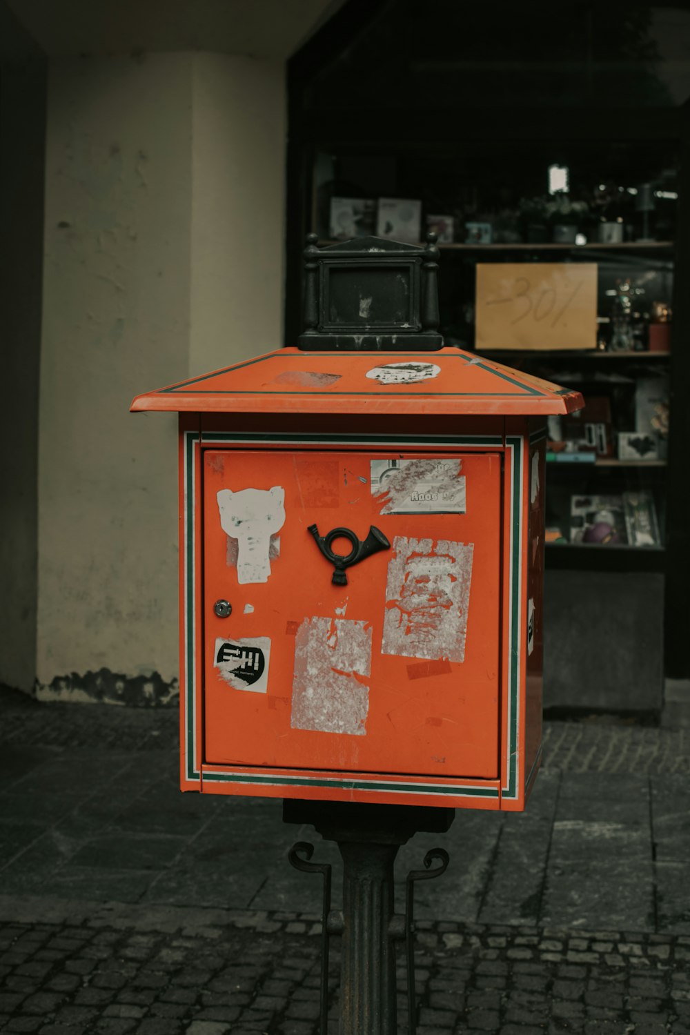 an orange mailbox sitting on the side of a street