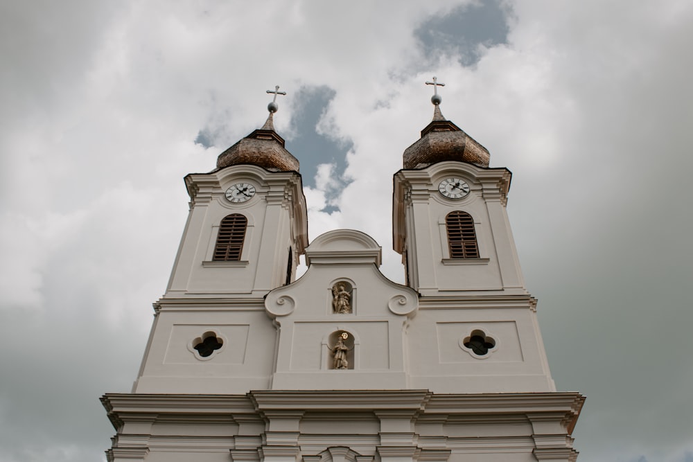 a large white church with two clocks on it's sides