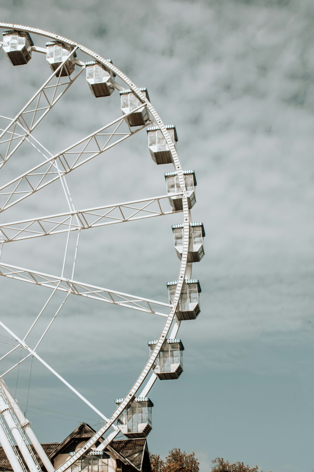 a large white ferris wheel on a cloudy day