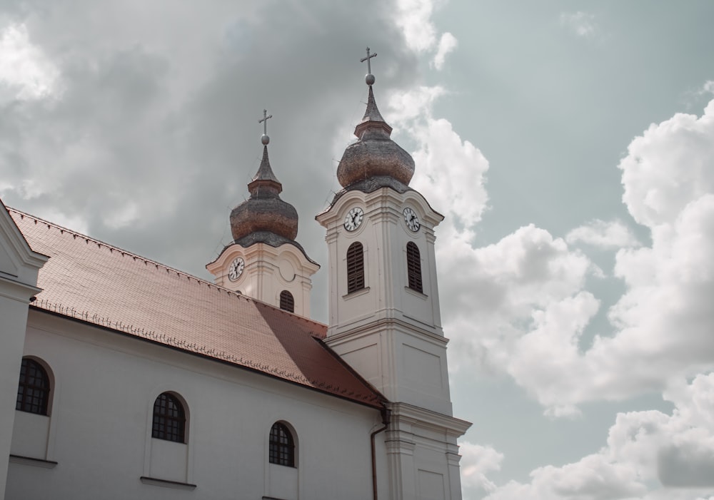 a large white church with two towers under a cloudy sky