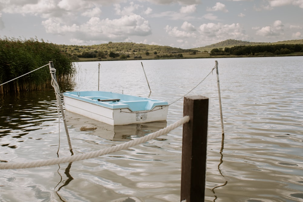 a small boat tied to a post in the water