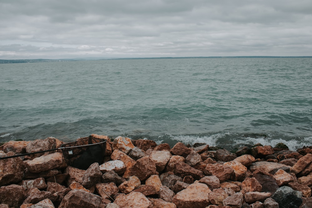 a pile of rocks next to a body of water