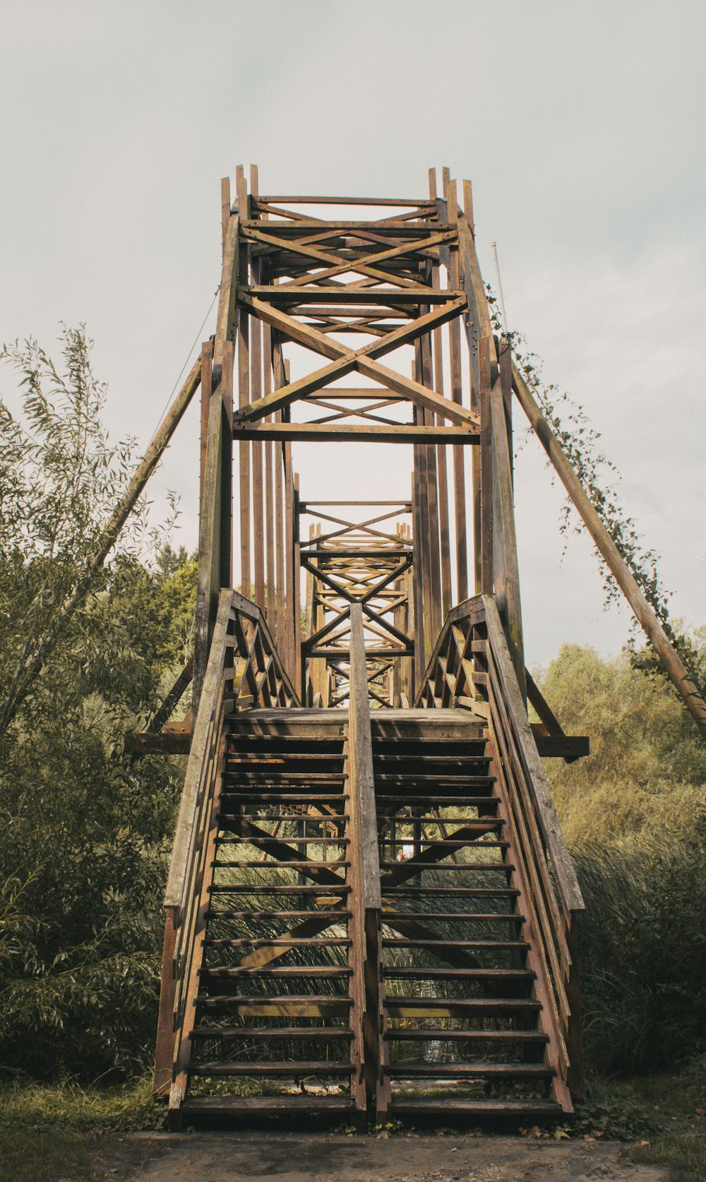 a tall wooden bridge with a bunch of stairs going up it