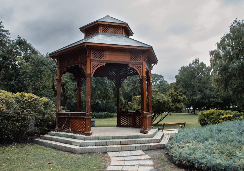 a wooden gazebo sitting in the middle of a park