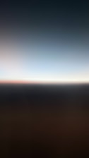 A gradient of colors fading from dark to light, with a blurry horizontal line separating two sections. The lower part is darker, while the upper part transitions into a lighter shade.