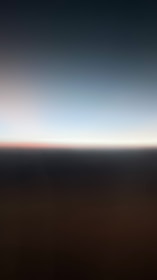A gradient of colors fading from dark to light, with a blurry horizontal line separating two sections. The lower part is darker, while the upper part transitions into a lighter shade.