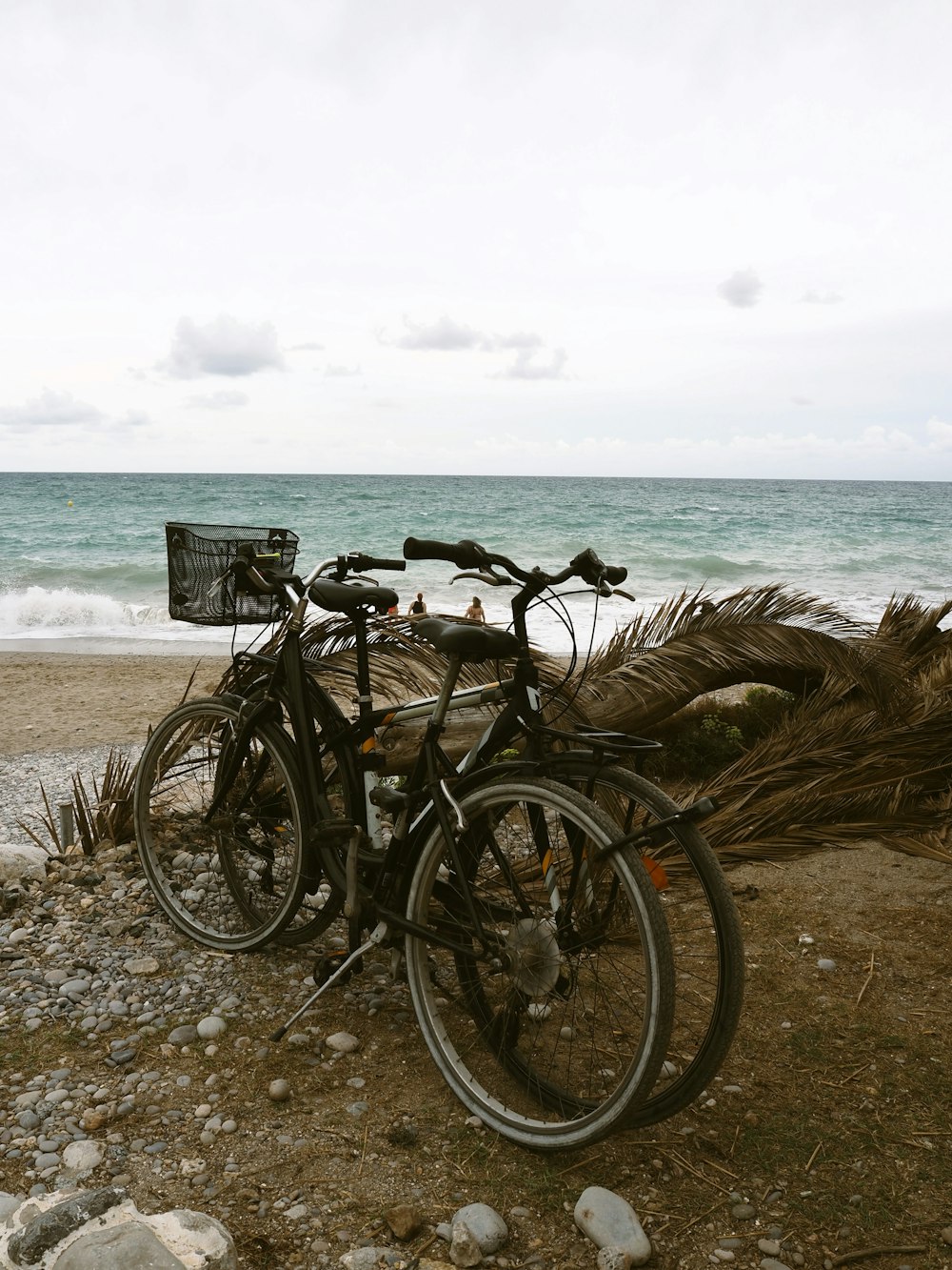 a couple of bikes parked on top of a sandy beach