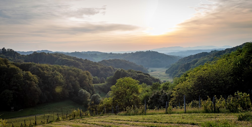 the sun is setting over the mountains in the valley