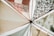 Various fabric panels with intricate patterns and earthy tones are stretched out and attached to wooden poles, creating a visually appealing canopy. The fabrics feature geometric and floral designs, adding an artistic flair.