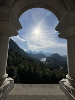 A breathtaking view of Pravčická brána arch framed by lush green forest under a clear blue sky.