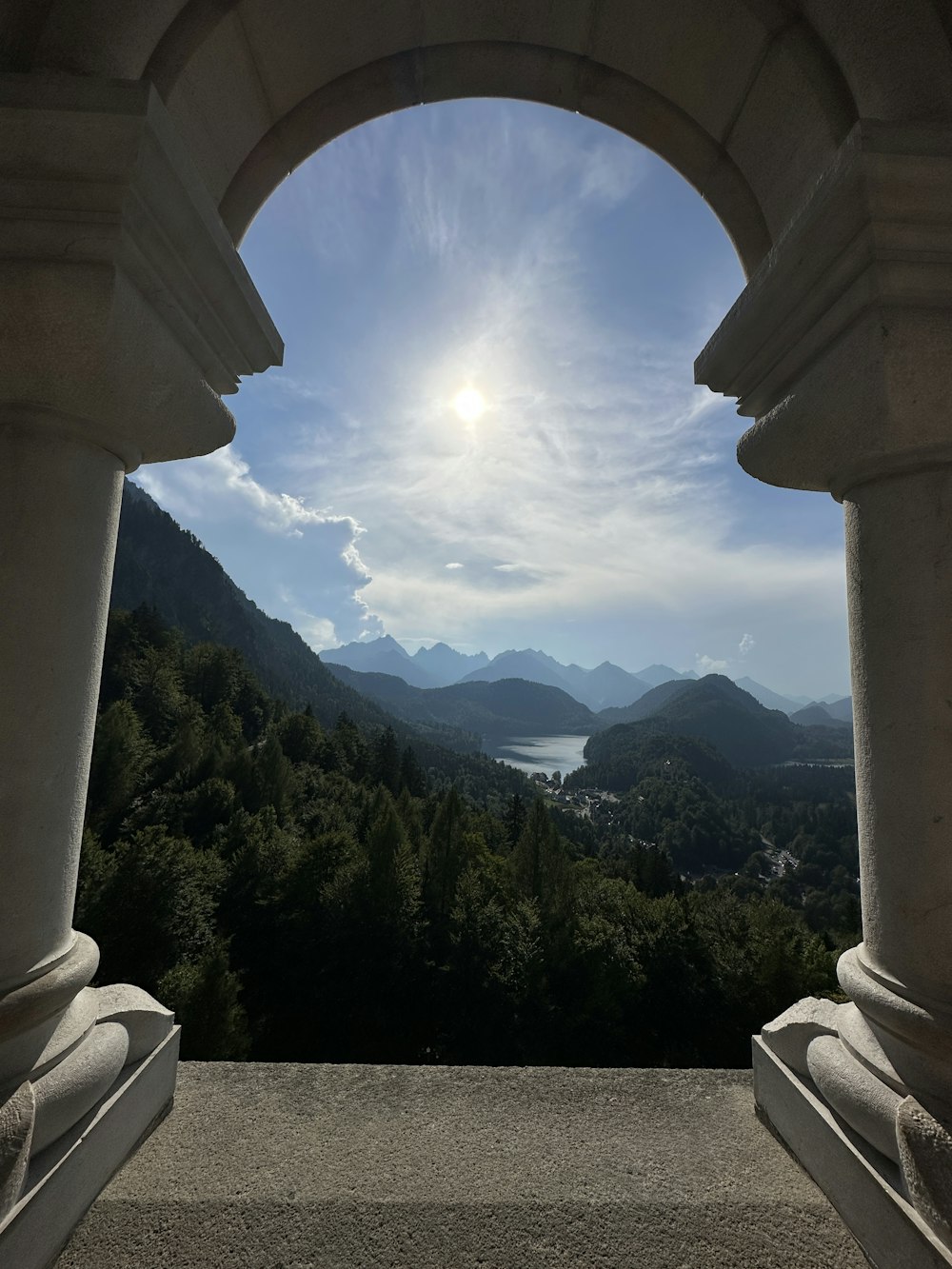 a view of a lake through a stone arch