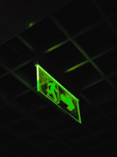 a green sign hanging from the ceiling of a building