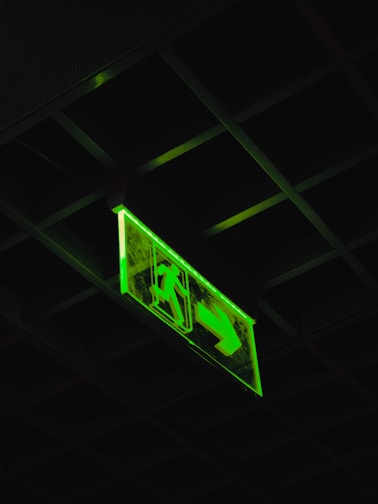 a green sign hanging from the ceiling of a building