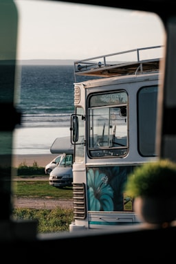 a bus parked on the side of the road next to the ocean