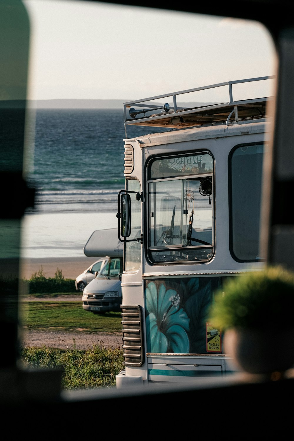 a bus parked on the side of the road next to the ocean