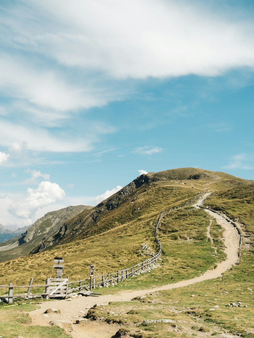 a dirt path going up a grassy hill