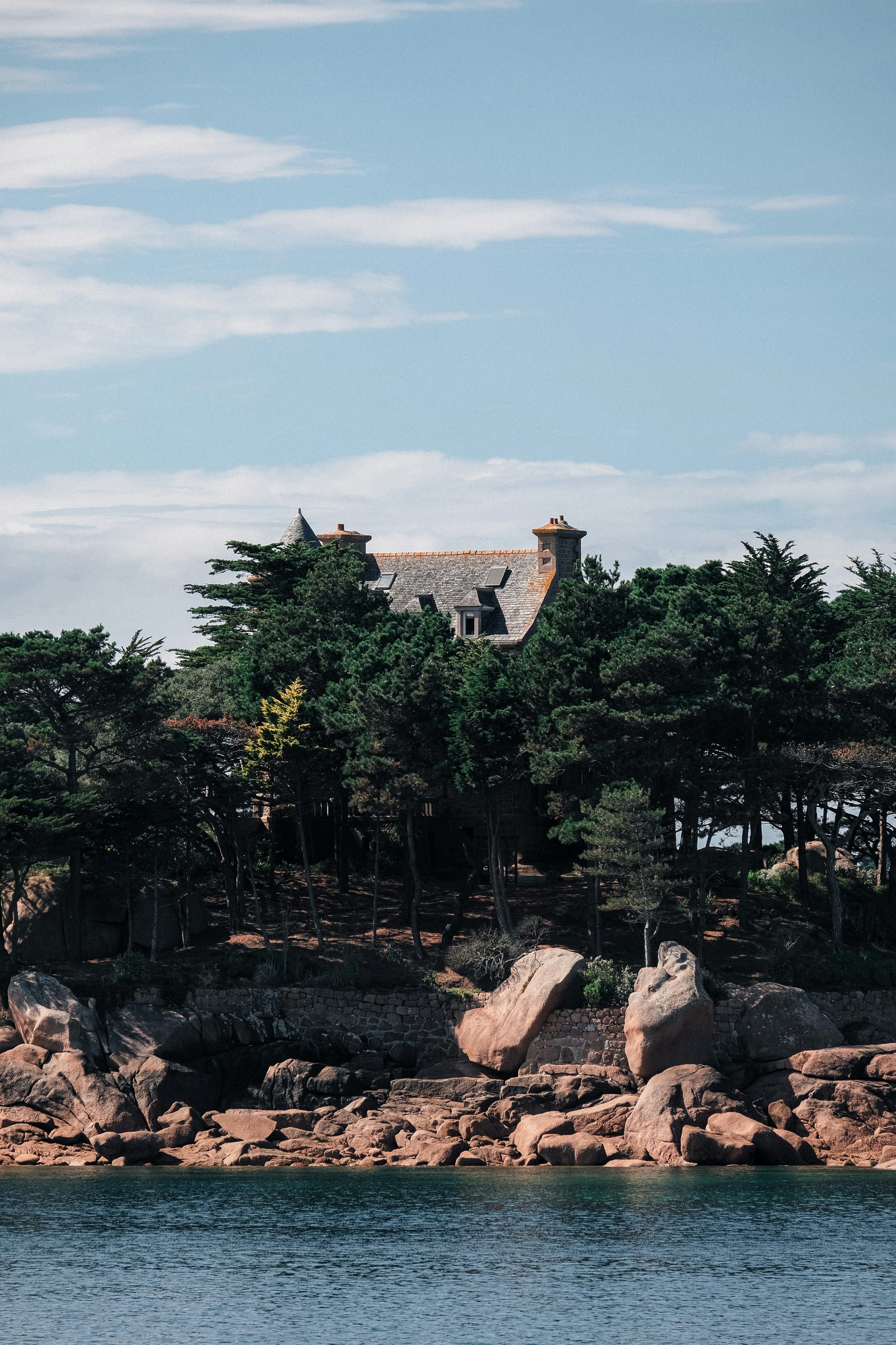 a large house sitting on top of a lush green hillside