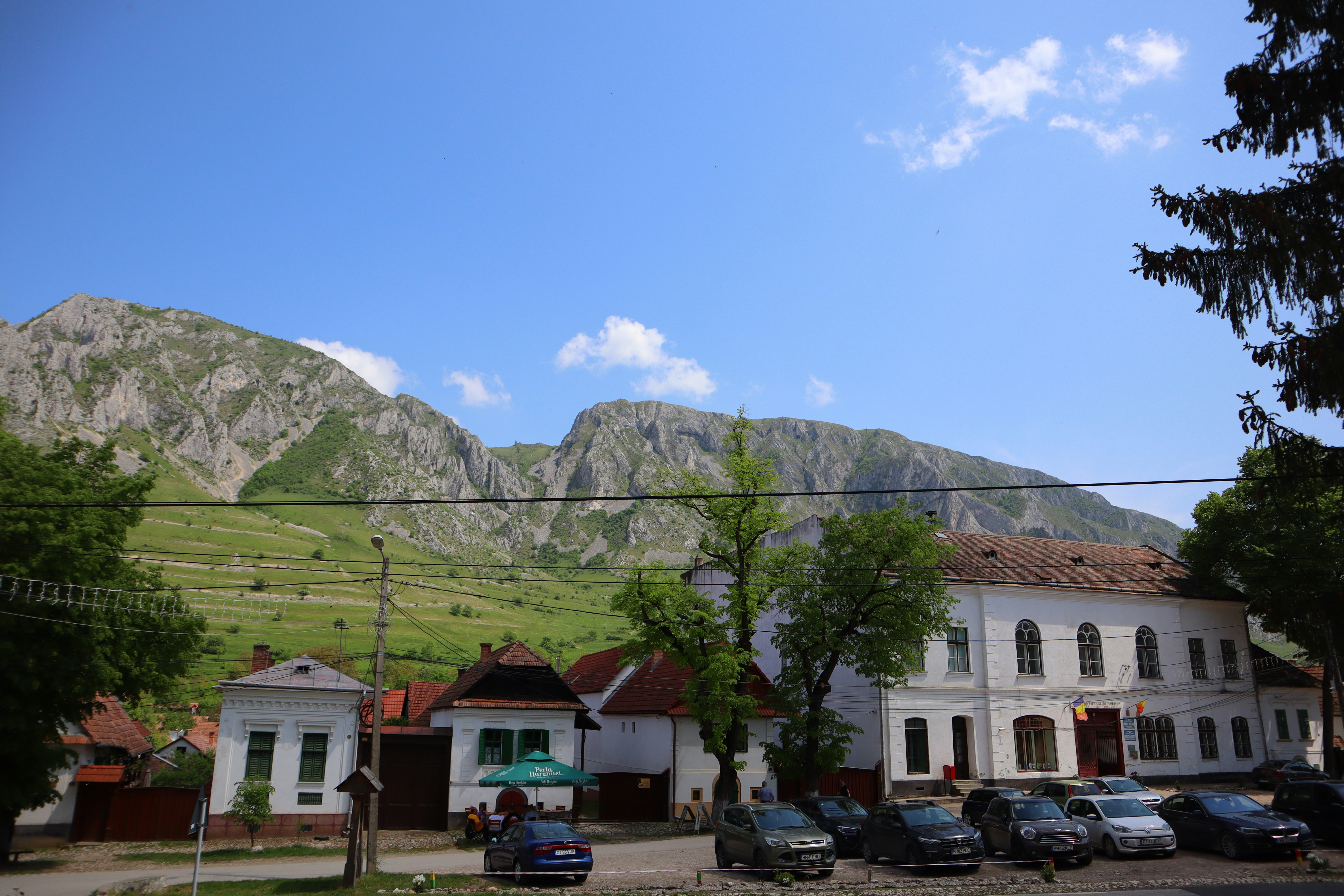 a large white building with a mountain in the background