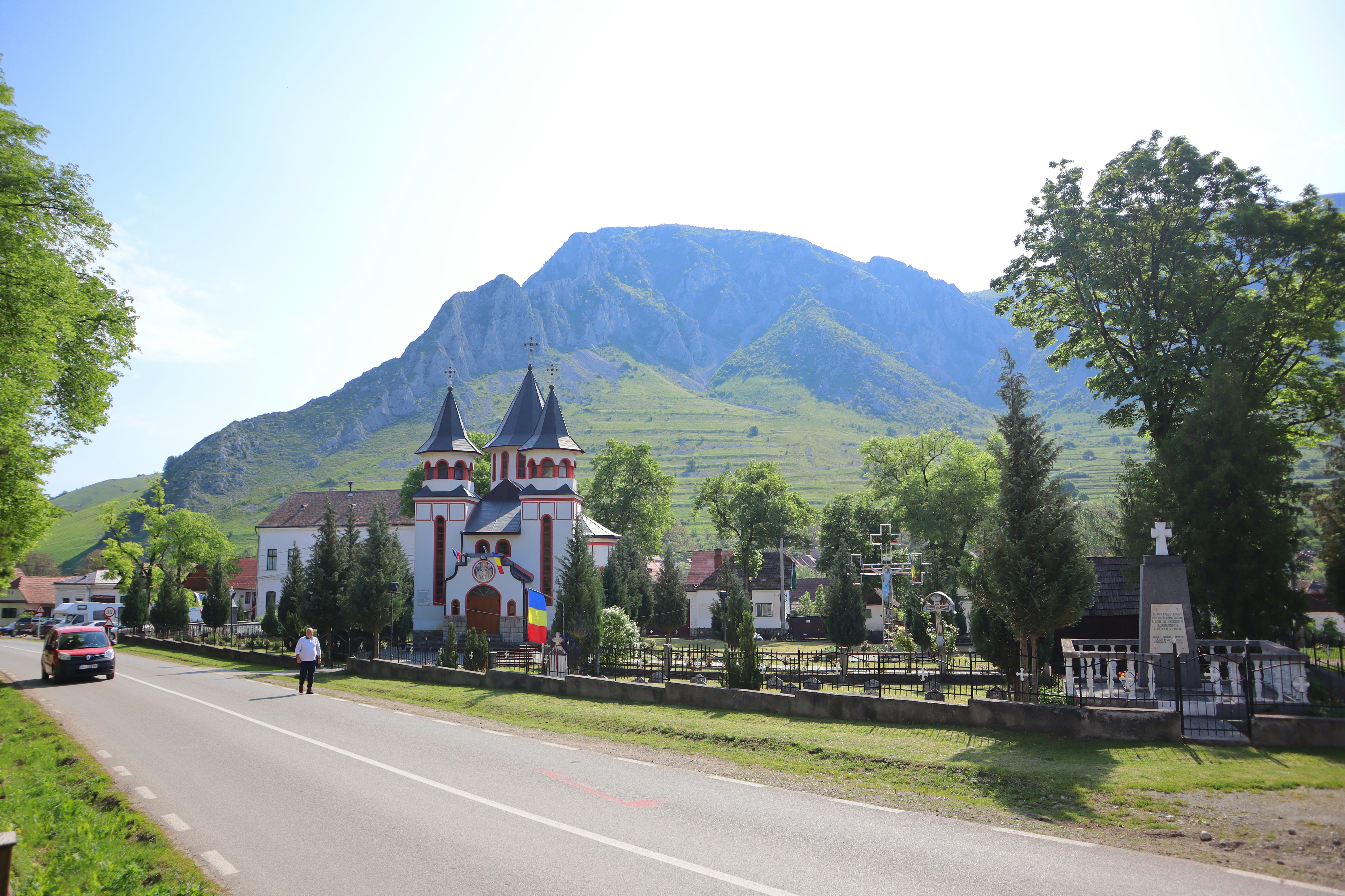 sebuah gereja di tengah jalan dengan latar belakang gunung