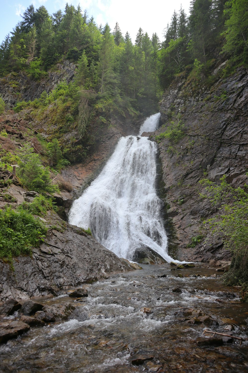 una cascata con una cascata che scende lungo il lato di esso