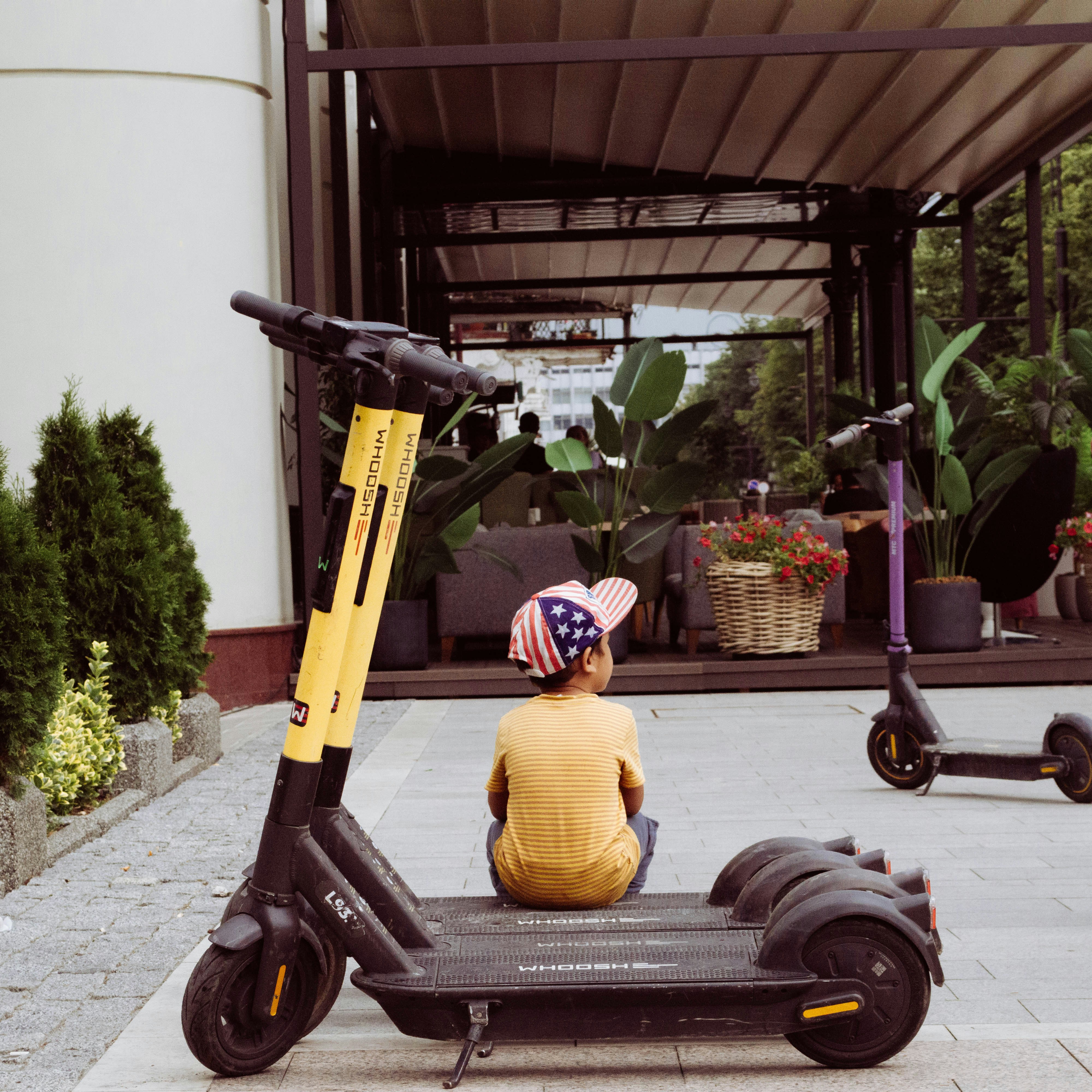 eine Person, die auf einem Roller vor einem Gebäude sitzt
