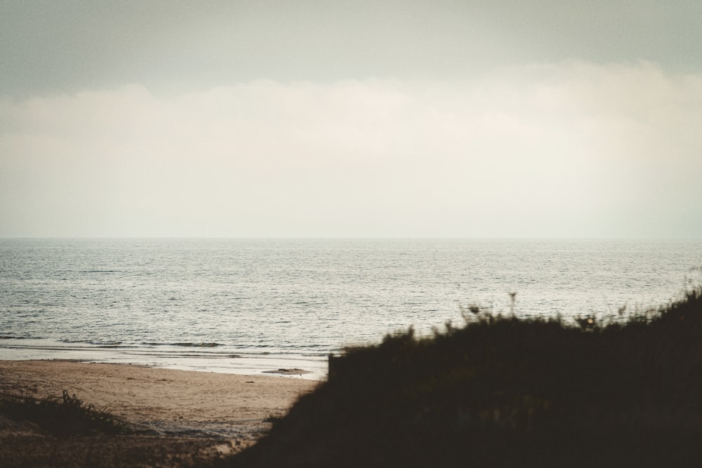 a person walking on the beach with a surfboard