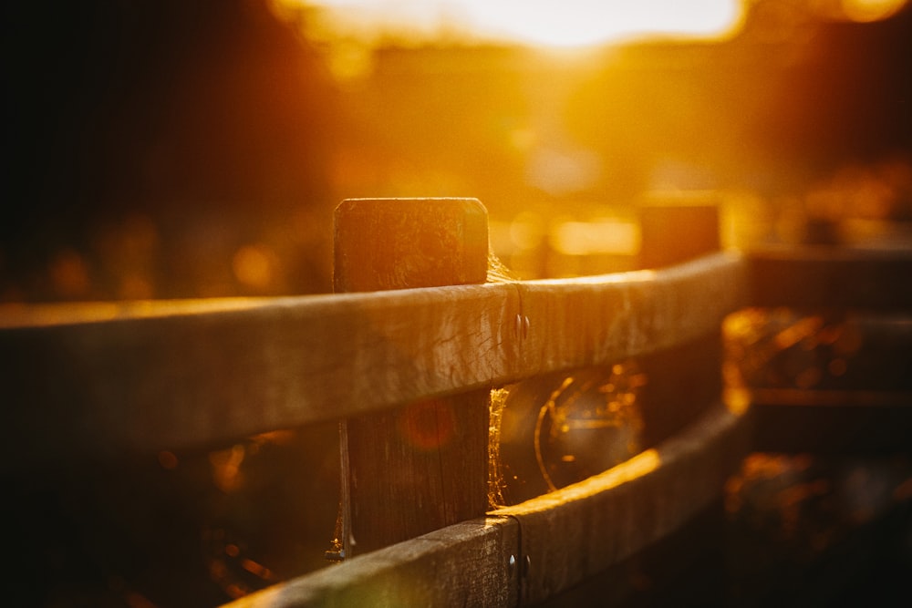 a close up of a wooden fence with the sun in the background