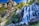 A scenic mountain waterfall surrounded by lush greenery under a clear sky.