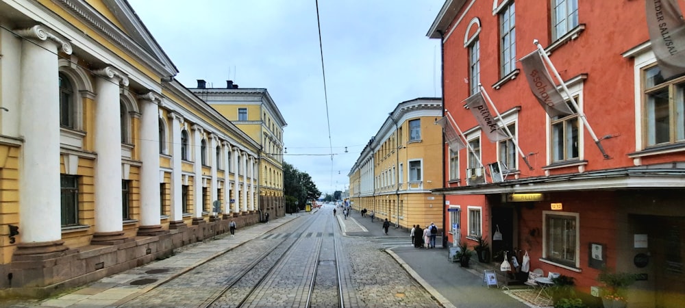 a street with a train track running between two buildings