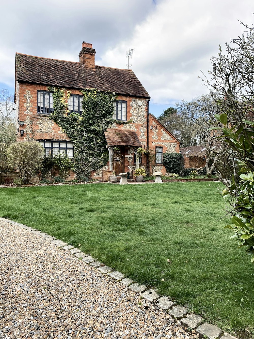 a large brick house with a green lawn