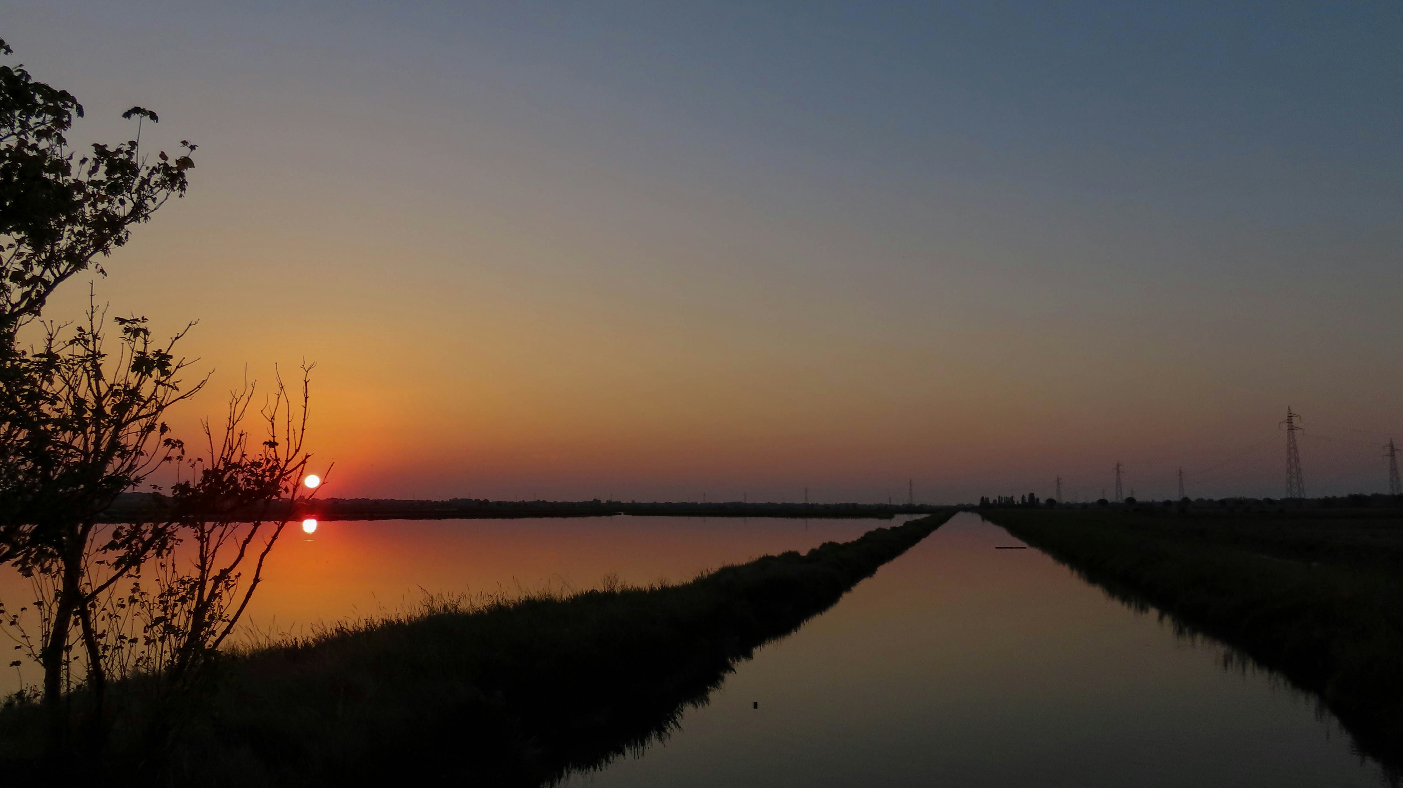 the sun is setting over a body of water