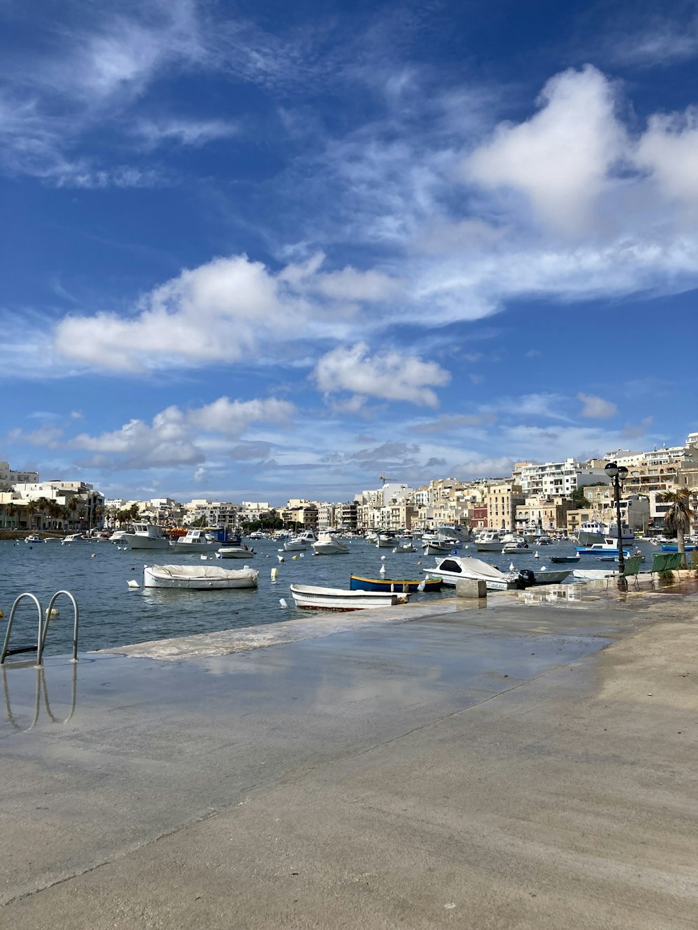 a beach with boats in the water and a city in the background