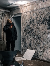 a man is taking a picture of mold growth on wall