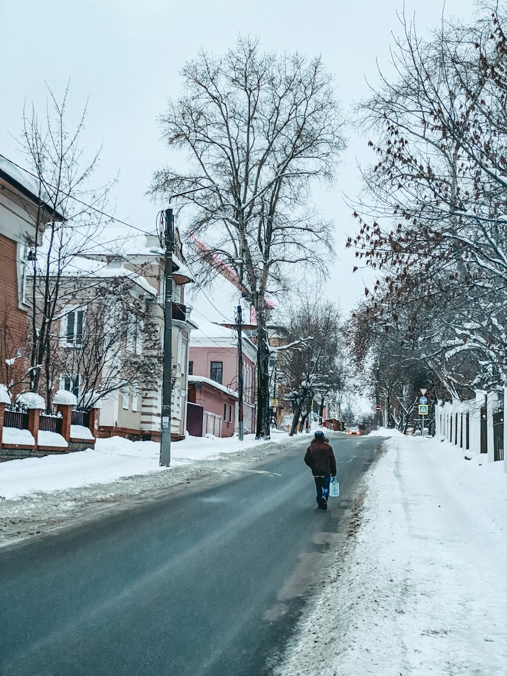 a person riding a bike down a snow covered street